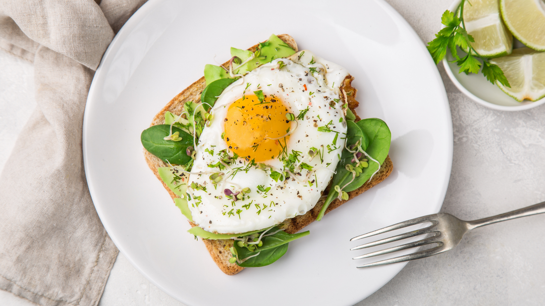 avocado toast with spinach herbs and a fried egg